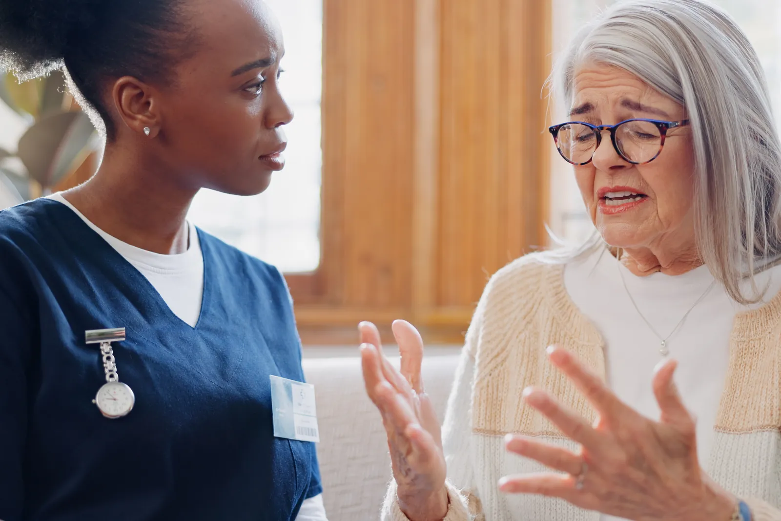 A nurse listens closely while an older woman explains something that worries her.